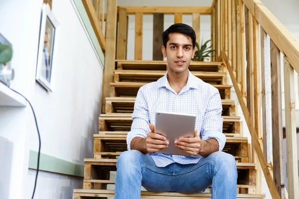 Porträt eines jungen Mannes, der im Büro an der Treppe sitzt — Stockfoto