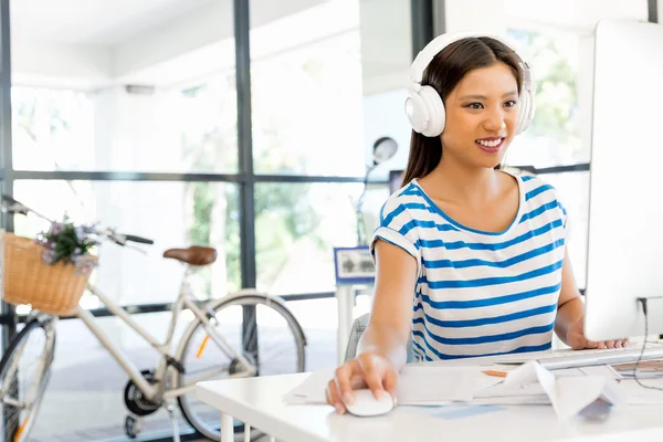 Young woman in office with headphones — Stock Photo, Image