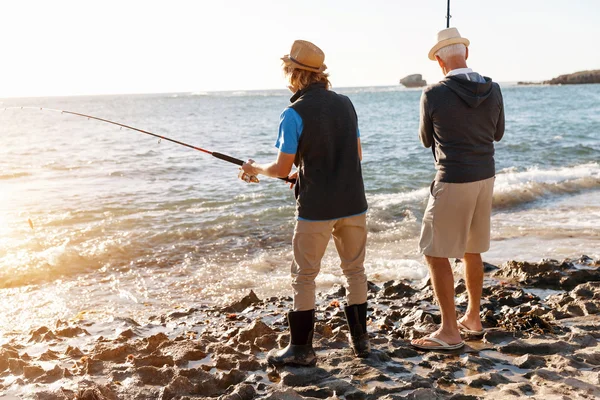 Uomo anziano pesca con suo nipote — Foto Stock