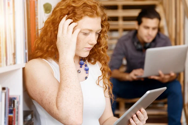 Portrait of two young people sitting at the stairs in office — Stock Photo, Image