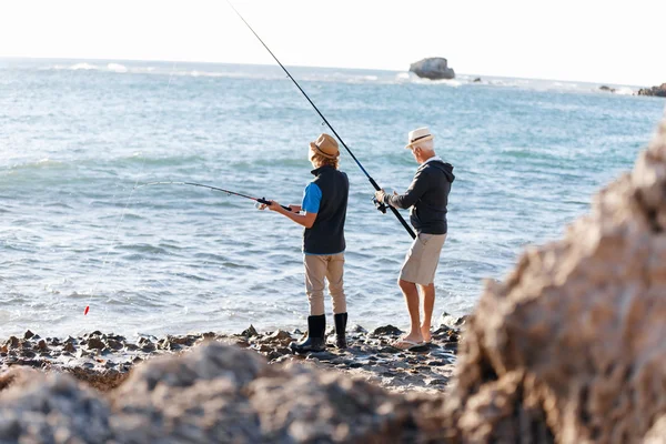 Hombre mayor pescando con su nieto —  Fotos de Stock