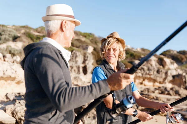 Hombre mayor pescando con su nieto — Foto de Stock