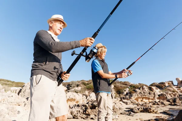 Uomo anziano pesca con suo nipote — Foto Stock