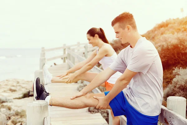 Runners. Young couple exercising on beach — Stock Photo, Image