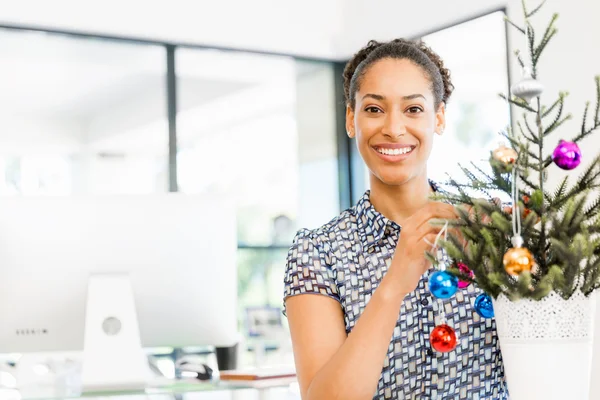 Porträtt av leende afro-american kontorist dekorera julgran i offfice — Stockfoto