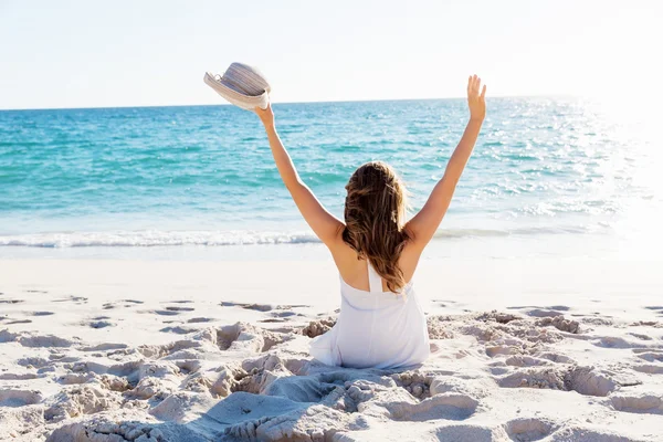 Jonge vrouw zittend op het strand — Stockfoto