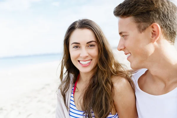 Romántica pareja joven sentada en la playa — Foto de Stock