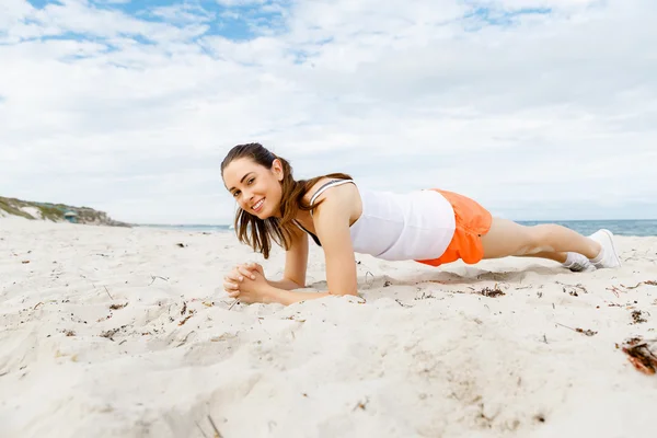 Jonge vrouw opleiding op strand buiten — Stockfoto