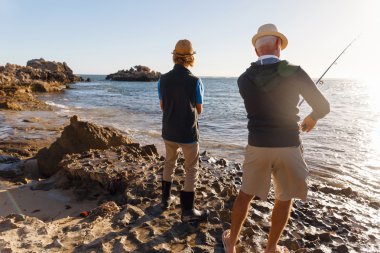 Yaşlı adam torunuyla balık tutuyor.