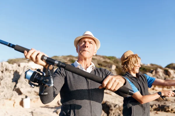 Uomo anziano pesca con suo nipote — Foto Stock