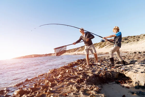 Uomo anziano pesca con suo nipote — Foto Stock