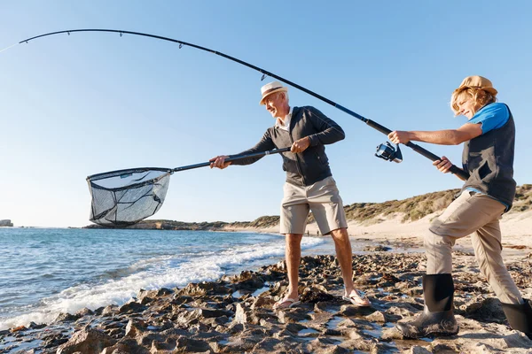 Starší muž rybaří se svým vnukem — Stock fotografie