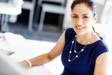 Çekici ofis çalışanı masada oturuyor.