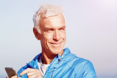 Erkek runner mobil akıllı telefonunu açık havada duran ile