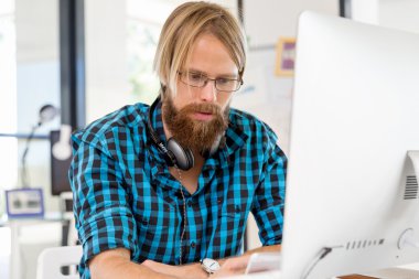 Genç adam ofiste çalışıyor.