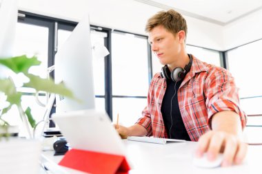 Genç adam ofiste çalışıyor.