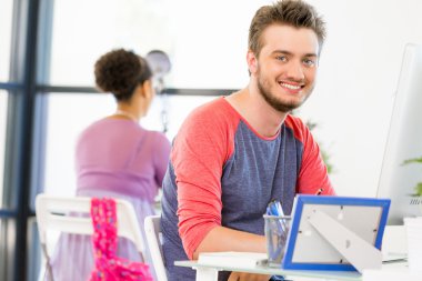 Genç adam ofiste çalışıyor.