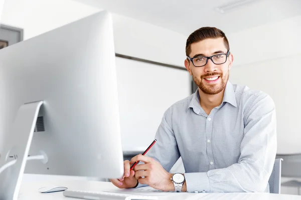 Männliche Büroangestellte sitzt am Schreibtisch — Stockfoto