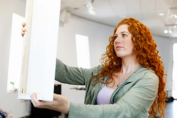 Jeune femme caucasienne debout dans la galerie d'art devant des peintures — Photo