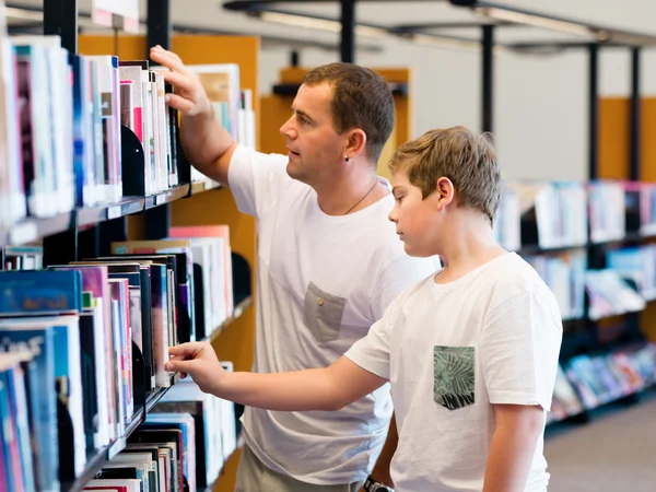 男孩和他父亲在图书馆 — 图库照片