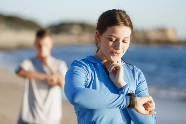 Runner woman with heart rate monitor running on beach — Stock Photo, Image