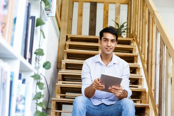 Portret van de jonge man zit bij de trappen in kantoor — Stockfoto