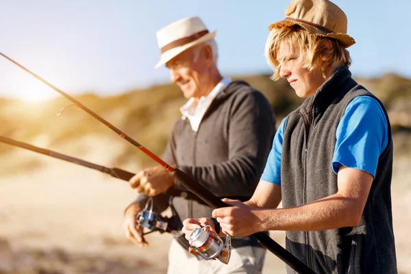 Uomo anziano pesca con suo nipote — Foto Stock