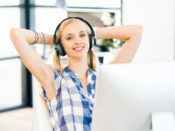 Young woman working in office with headphones — Stock Photo, Image