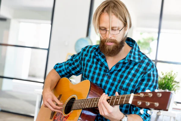 Homem tocando guitarra no escritório — Fotografia de Stock