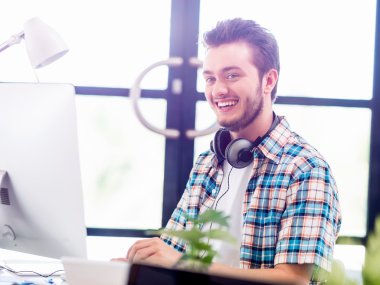 Genç adam ofiste çalışıyor.