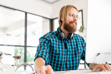 Genç adam ofiste çalışıyor.