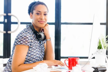 Afro-Amerikan ofis çalışanı iş içinde oturan gülümseyen portresi