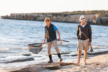 Yaşlı adam torunuyla balık tutuyor.