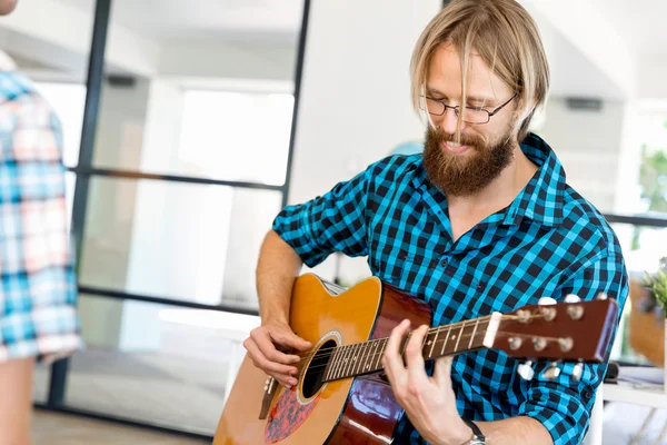 Homem tocando guitarra no escritório — Fotografia de Stock