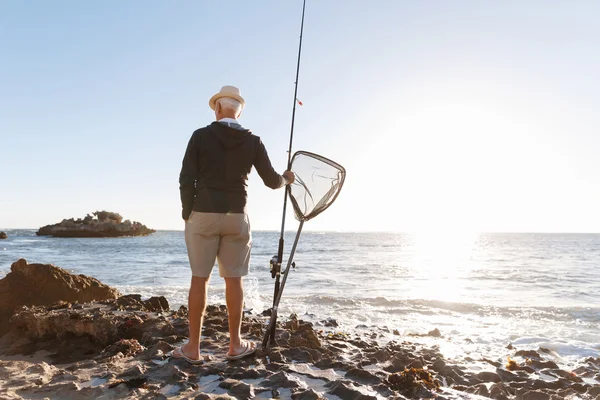 Homem sênior de pesca ao lado do mar — Fotografia de Stock