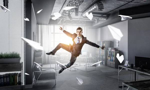 Empresario saltando en la oficina. Medios mixtos — Foto de Stock