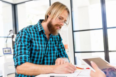 Genç adam ofiste çalışıyor.