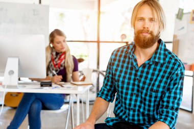 Genç adam ofiste çalışıyor.