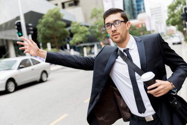 Young businessman hailing for a taxi clipart