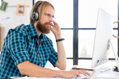 Genç adam ofiste çalışıyor.