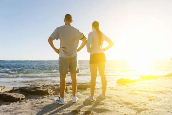 Jong (echt) paar op het strand training samen — Stockfoto