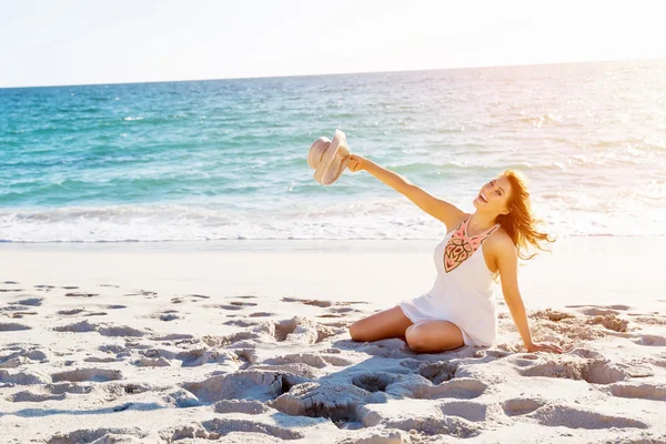 Ung kvinna sitter på stranden — Stockfoto