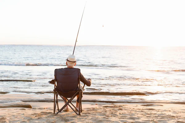 Senior man fishing at sea side — Stock Photo, Image