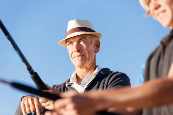 Hombre mayor pescando con su nieto — Foto de Stock