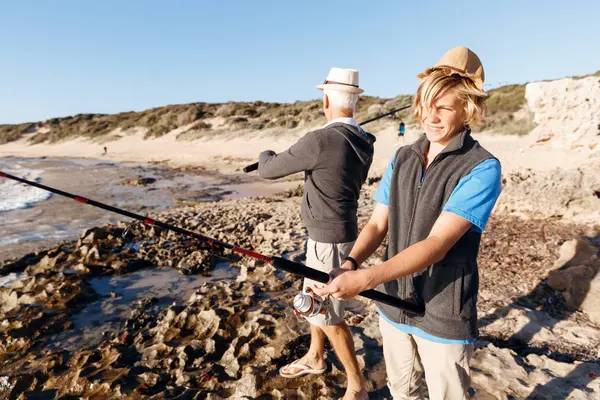 Uomo anziano pesca con suo nipote — Foto Stock