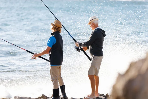 Yaşlı adam torunuyla balık tutuyor. — Stok fotoğraf
