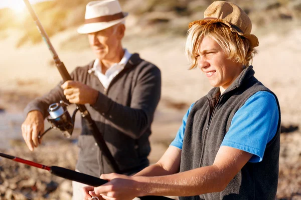 Hombre mayor pescando con su nieto — Foto de Stock