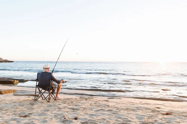 Senior man fishing at sea side — Stock Photo, Image