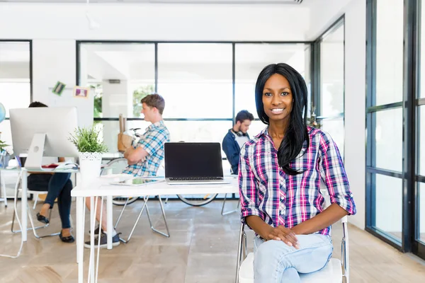 Portret van Afro-Amerikaanse kantoor werknemer zitten in offfice glimlachend — Stockfoto