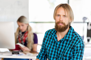 Genç adam ofiste çalışıyor.